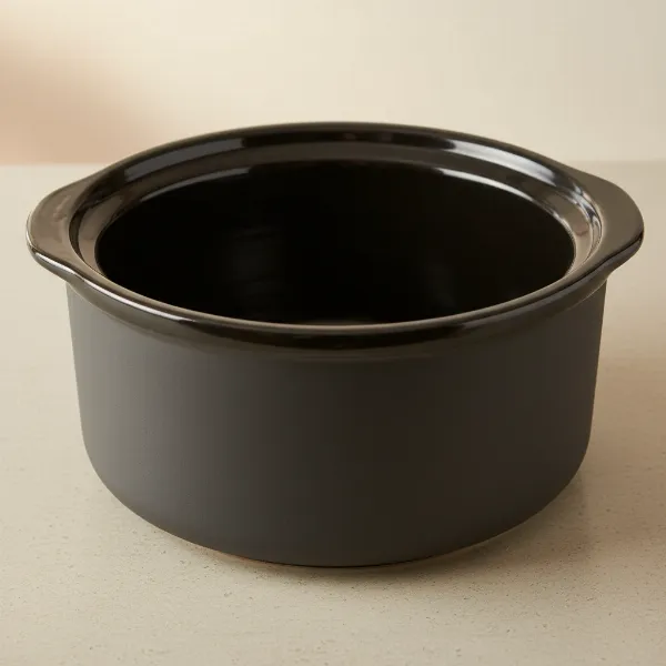 A ceramic stoneware insert for a slow cooker, showing its thick walls and glazed interior.